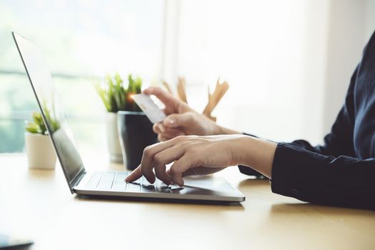 Online payment, Young Women's using computer and hands holding credit card for online shopping