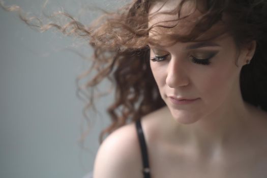 Portrait of a beautiful sensual young woman with curly hair