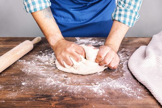 hands of an unrecognizable man kneading homemade bread dough, concept of healthy food at home