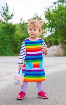 The child draws with chalk on the pavement. Selective focus. Kid.