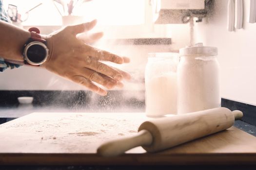 unrecognizable man hands clapping with flour on the kitchen table, concept of healthy food at home