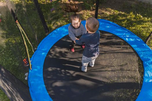 top view of small children jumping on a trampoline