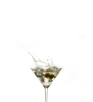 detail of a cocktail glass with an alcoholic preparation of ice and olives. Splash of an ice inside a crystal glass on a white background. drink concept. copy espace.