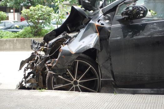 black car damaged by a road accident .