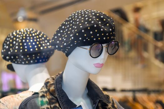 Mannequin in beret and glasses in a shop window