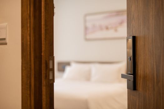 Open the door. Hotel room, Condominium or apartment doorway with open door in front of blur bedroom background