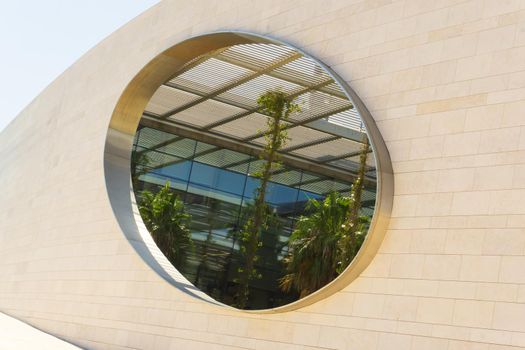 A modern building with tropical plants and palm trees inside.