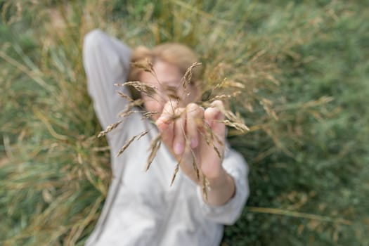 Girl showing dry golden grass