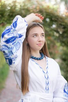 ukrainian blonde girl in national blue dress - embroidered shirt. young woman patriot. outdoors photo of charming female.