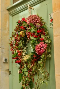 Multi-colored wreath with hydrangeaon and ivy on a wooden door