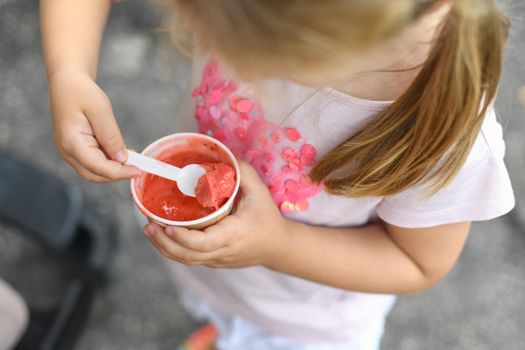 Girl eats pink ice cream