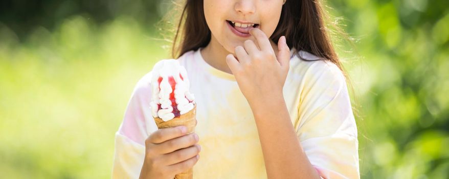 Beautiful little girl eats ice-cream in the summer.