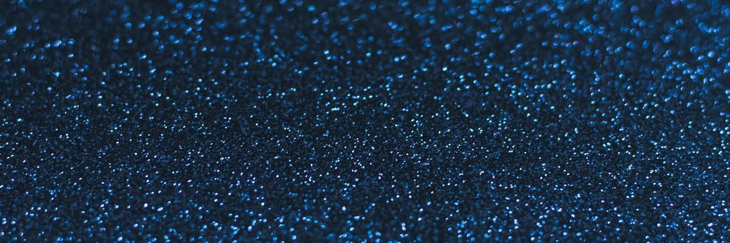 Glowing sparkles on blue color trendy background. Holiday bright brilliant beautiful background, template for blog or designers. Web banner. New Year 2020.