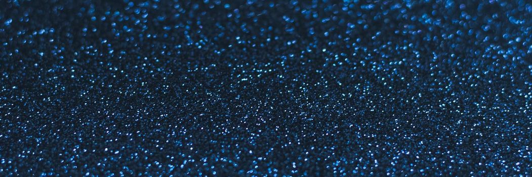 Glowing sparkles on blue color trendy background. Holiday bright brilliant beautiful background, template for blog or designers. Web banner. New Year 2020.