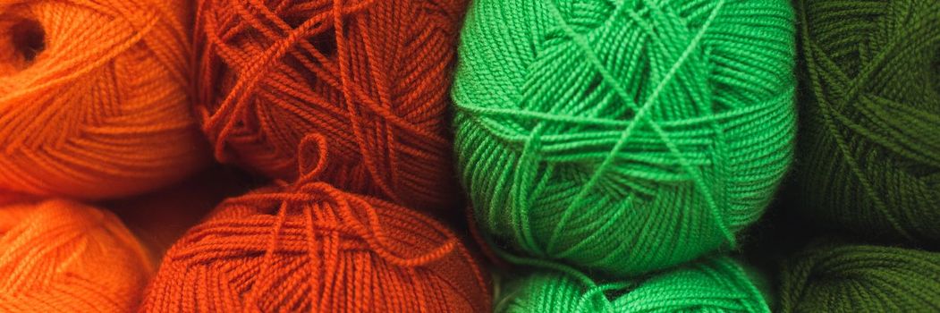 Colored skeins of wool on a store shelf. Woolen skeins for knitting all the colors of the rainbow, green, brown, red and orange. Web banner.