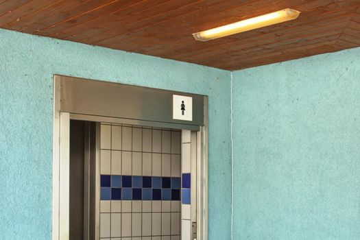 Women restroom near swimming pool, entrance with ladies toilet icon.