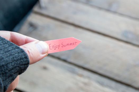 Enjoy summer concept. A man holds a pointer with an inscription. High quality photo