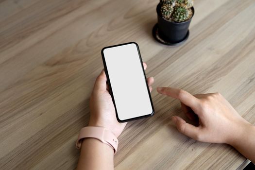 Top view Woman sitting and holding blank screen mock up mobile phone.
