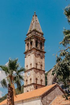 Historic city of Perast at Bay of Kotor in summer, Montenegro. Scenic panorama view of the historic town of Perast at famous Bay of Kotor with blooming flowers on a beautiful sunny day with blue sky and clouds in summer, Montenegro, southern Europe