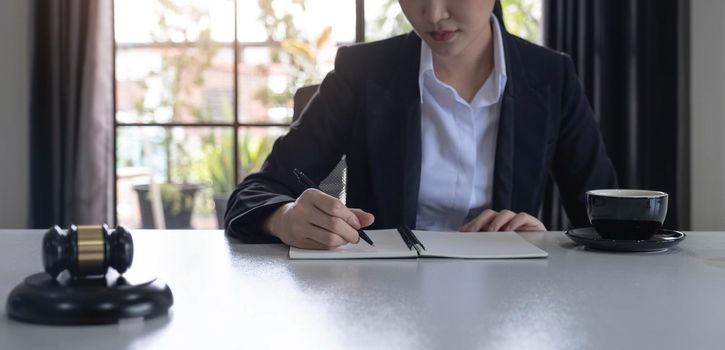 Business woman and lawyers discussing contract papers with brass scale on wooden desk in office. Law, legal services, advice, Justice and real estate concept..