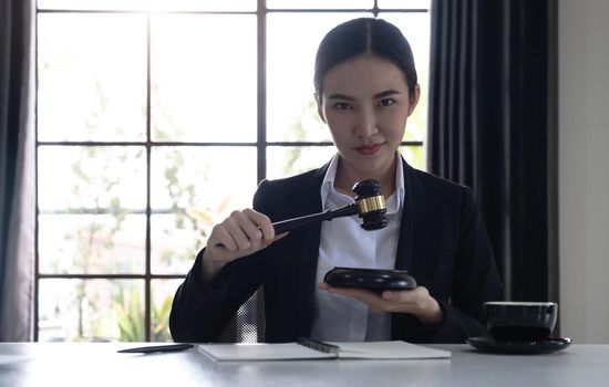 selective focus of brunette lawyer in formal wear holding pen near insurance policy documents and looking at camera.