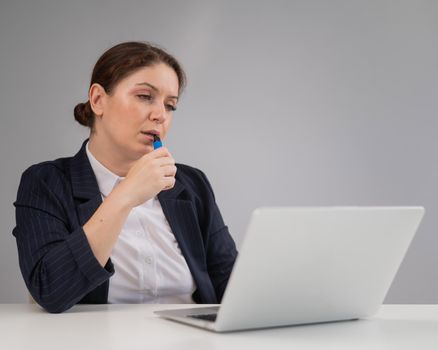 Business woman smoking a disposable vape while sitting at her desk