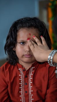 Indian families celebrating Raksha Bandhan festival a festival to celebrate the bond between brother and sister. Rakhi celebration in India. Feeding sweets, applying tikka.