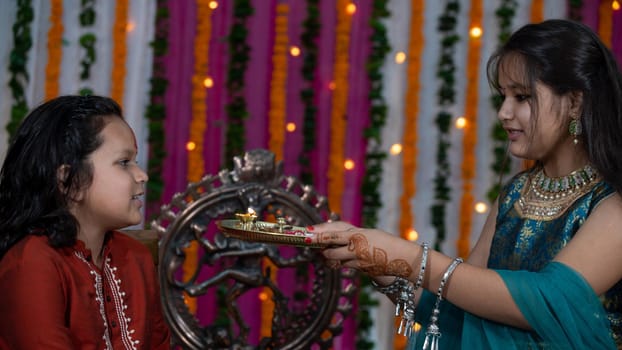 Indian families celebrating Raksha Bandhan festival a festival to celebrate the bond between brother and sister. Rakhi celebration in India. Feeding sweets, applying tikka.