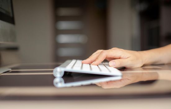 Female hands typing text on the keyboard while exchanging messages with friends via social networks using a computer laptop. A female office worker checks her email while sitting at a desk.