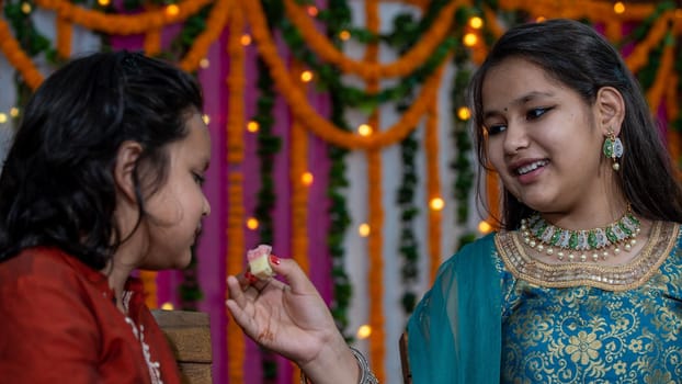 Indian families celebrating Raksha Bandhan festival a festival to celebrate the bond between brother and sister. Rakhi celebration in India. Feeding sweets, applying tikka.