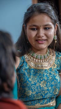 Indian families celebrating Raksha Bandhan festival a festival to celebrate the bond between brother and sister. Rakhi celebration in India. Feeding sweets, applying tikka.