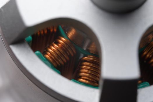 Closely looking down into tall copper coils or stators within a brushless electric drone motor. Three color metallic theme, very detailed close up.