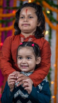 Indian children wearing ethnic Indian dress during Raksha Bandhan, a festival to celebrate the bond between brother-sister. Decoration in Indian houses.