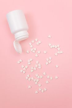 Global Pharmaceutical Industry and Medicinal Products - White Pills or Tablets Scattered from the Pill Container, Lying on Pink Background