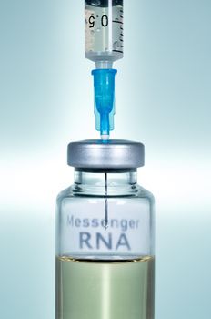 Macro of a hypodermic syringe or needle being filled with mRNA vaccine from bottle against a blue background