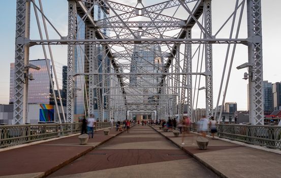 Tourists on the John Seigenthaler pedestrian bridge or Shelby street crossing leaving downtown Nashville Tennessee