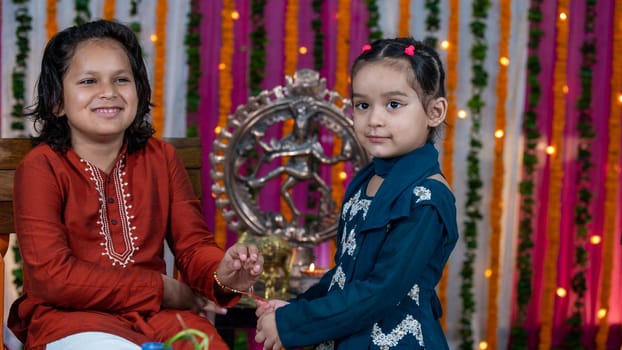 Indian families celebrating Raksha Bandhan festival a festival to celebrate the bond between brother and sister. Rakhi celebration in India. Feeding sweets, applying tikka.