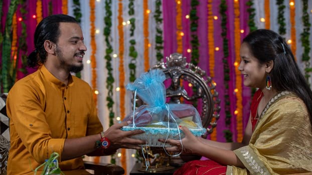 Indian families celebrating Raksha Bandhan festival a festival to celebrate the bond between brother and sister. Rakhi celebration in India. Feeding sweets, applying tikka.