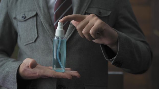 Male Hands Demonstrating Sanitizer Spray, Close Up Of Business Man's Hands Holding Bottle With Antiseptic Fluid Which Need To Be Used Due To Epidemic Of Coronavirus, Front View