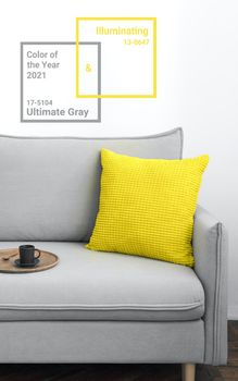 Illuminating yellow and ultimate Gray - trendy colors of year 2021 in interior. Gray sofa with yellow pillow in modern scandinavian style room interior. Vertical crop for social media, copy space