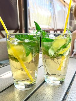 selective focus. refreshing detox drink with mint ginger and lemon. Cold mojito cocktail. A mint soft drink is healthy. Fresh mint, lime slices in cold water. High quality photo