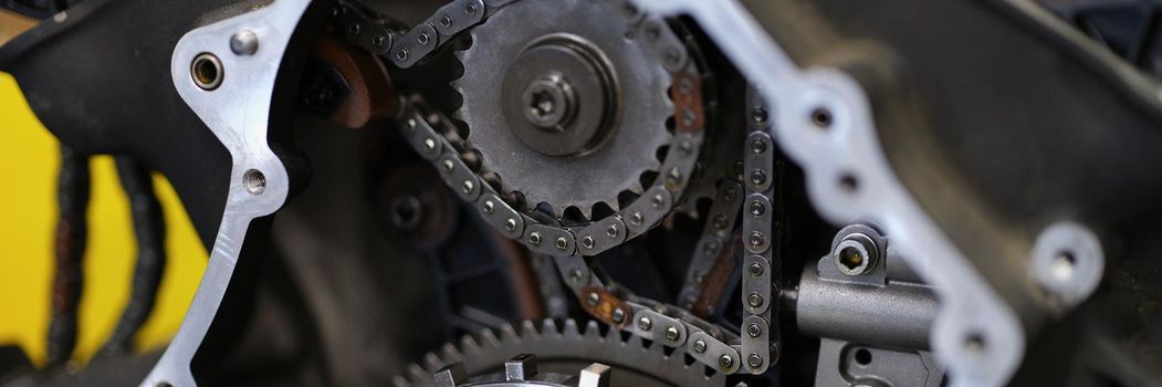 Close-up of motorbike construction system with metal chain and others details. Brand new bike or just after maintenance in service centre. Vehicle concept