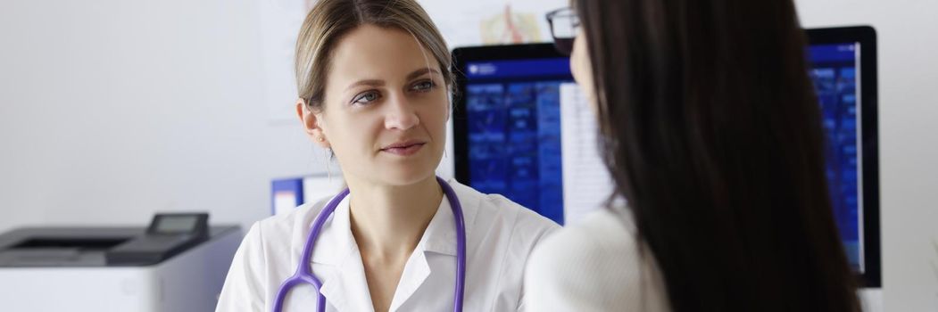 Portrait of patient on appointment explain problem to medical worker in clinic. Female doctor listen to complaints. Health, medicine, diagnostic concept