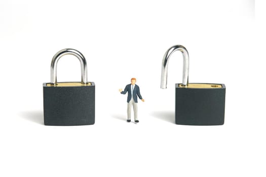 Miniature people toy figure photography. Lockdown option concept. A shrugging businessman stand in the middle of opened and closed padlock. Isolated on white background. Image photo