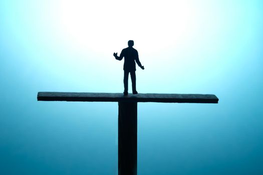 Miniature people toy figure photography. Business choice concept. A Silhouette of shrugging businessman stand above scales equilibrium. Image photo