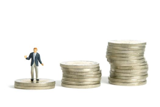 Miniature people toy figure photography. Financial plan concept. A shrugging businessman stand above increasing coin money stack. Isolated on white background. Image photo