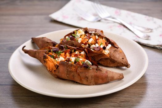 Baked sweet potato stuffed with chopped sun-dried tomatoes, olives, feta cheese and basil with aromatic dressing