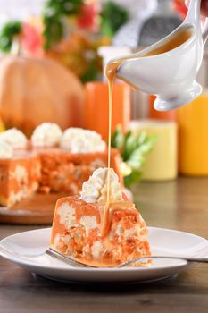 Slice of Pumpkin and cottage cheese casserole with caramel topping on a plate. This is a delicious dessert filled with autumnal notes. It is full of pumpkin spice aromas, creamy softness with raisins.