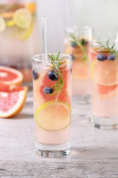 Paloma cocktail or lemonade with lime, grapefruit, blueberries and rosemary. Refreshing organic drink