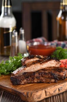 Delicious Baked Grilled Sliced pork belly with barbeque  sauce plating on wooden plate,  herbs and vegetables